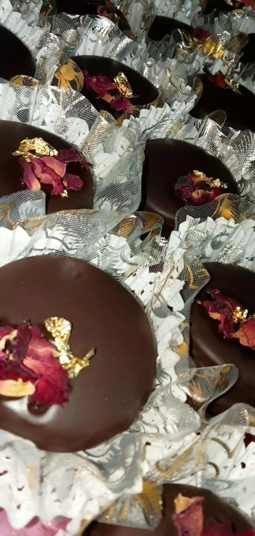Bouchées enrobées de chocolat noir, décorées de pétales de rose séchée et de feuille d'or, MANGO DZ à Oran